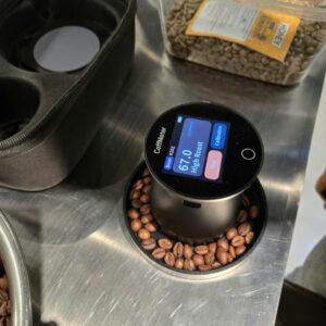 Máy đo màu rang cà phê CoffMeter hiển thị chỉ số 67.0 High Roast trên khay mẫu hạt rang tại Stone Village Lab