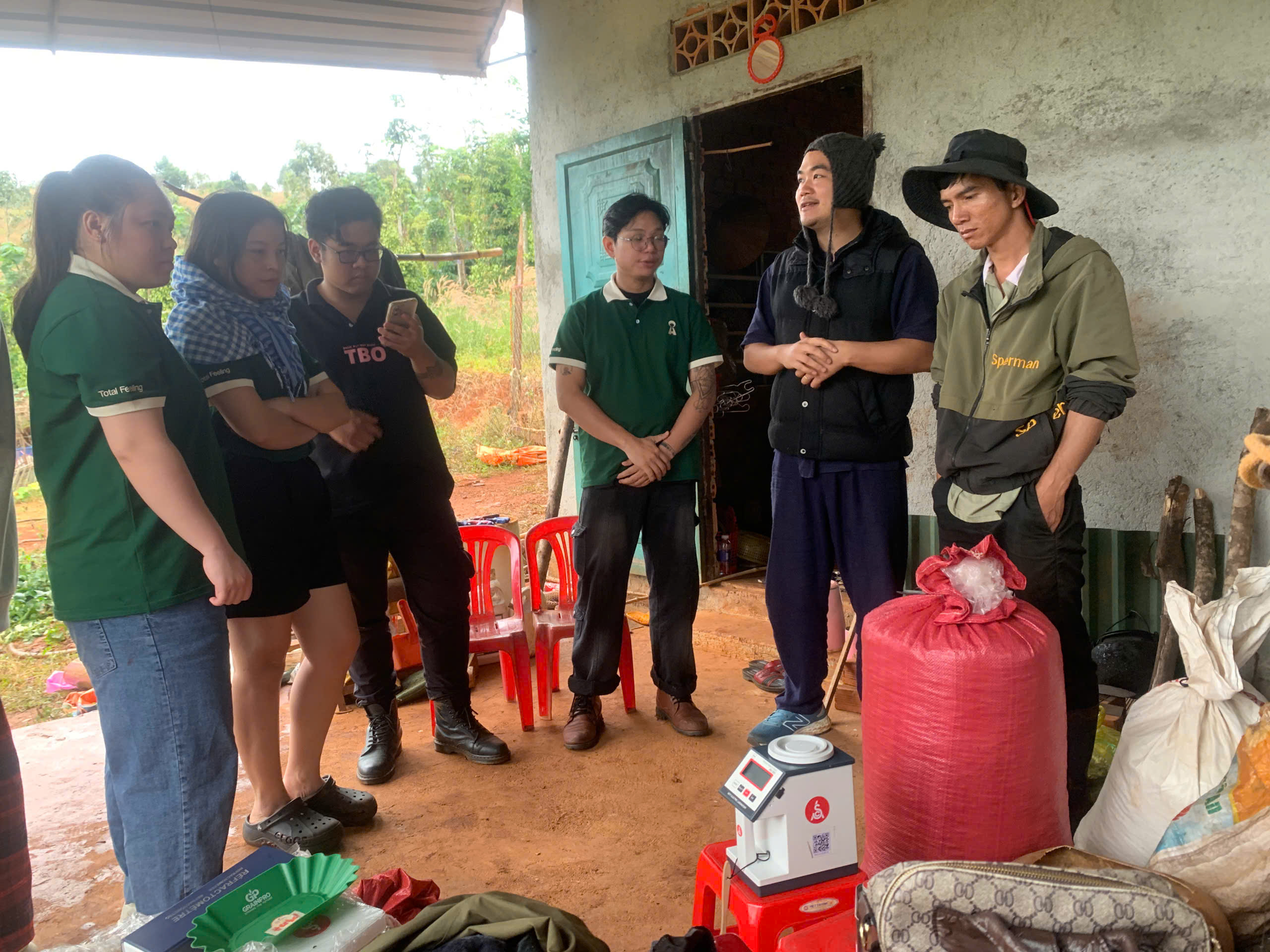 Đoàn Stone Village Lab trao đổi cùng nông dân bên bao cà phê và máy đo độ ẩm tại Đắk Song, Đắk Nông