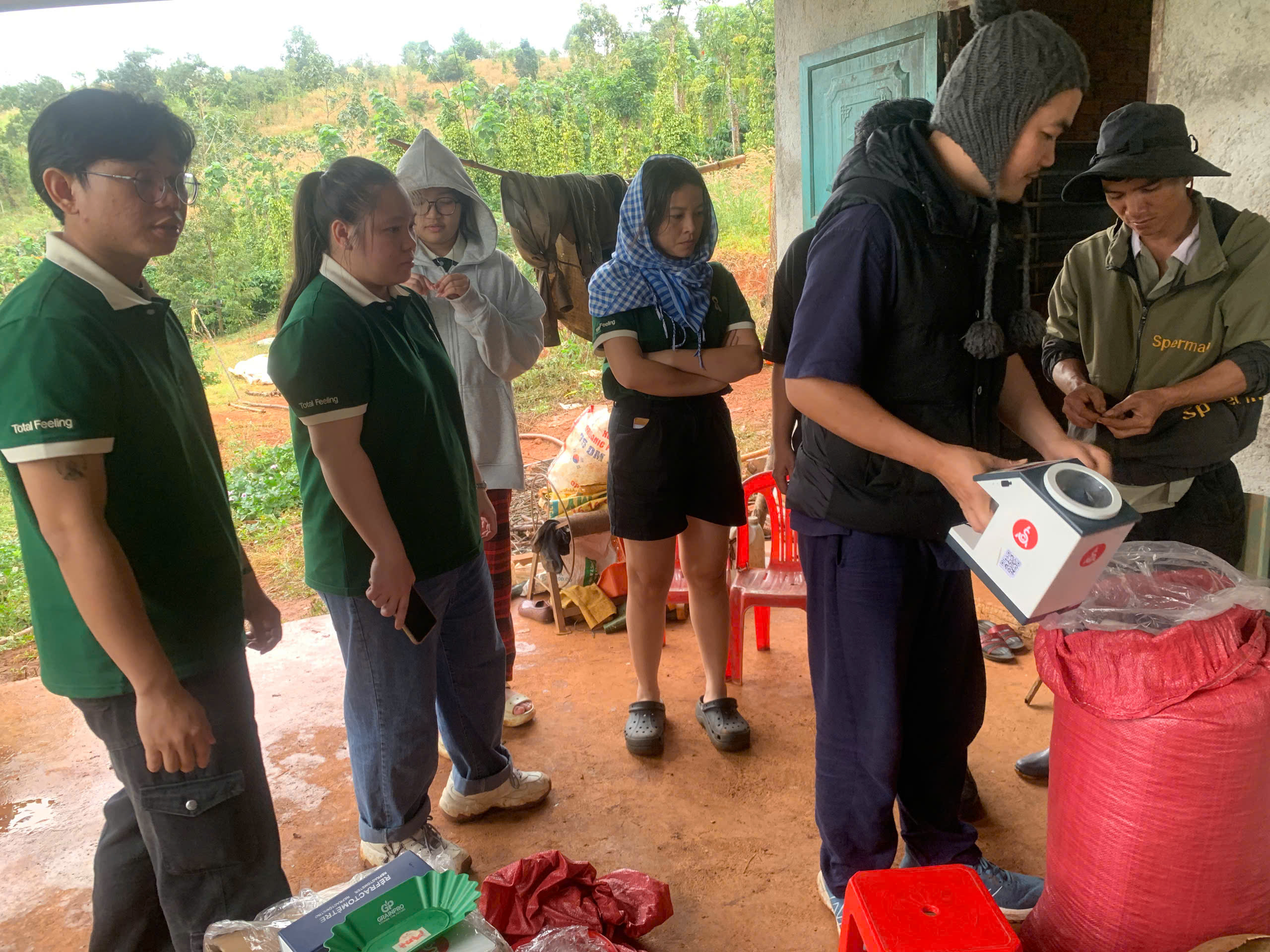 Nông dân Đắk Song đổ mẫu cà phê vào máy đo độ ẩm dưới sự hướng dẫn của Stone Village Lab