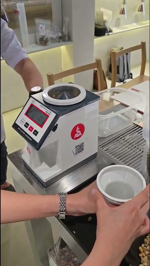 Đo ẩm độ cà phê nhân xanh bằng máy Kett PM-450 Đổ mẫu cà phê nhân xanh vào máy đo ẩm độ Kett PM-450 và đọc kết quả phần trăm ẩm