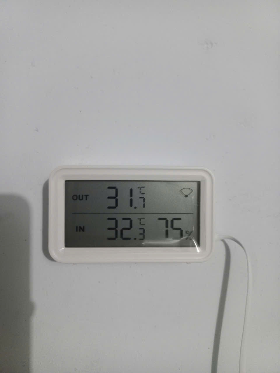 Nhiệt ẩm kế hiển thị nhiệt độ trong 32.3 độ C và độ ẩm không khí 75 phần trăm tại khu bảo quản cà phê