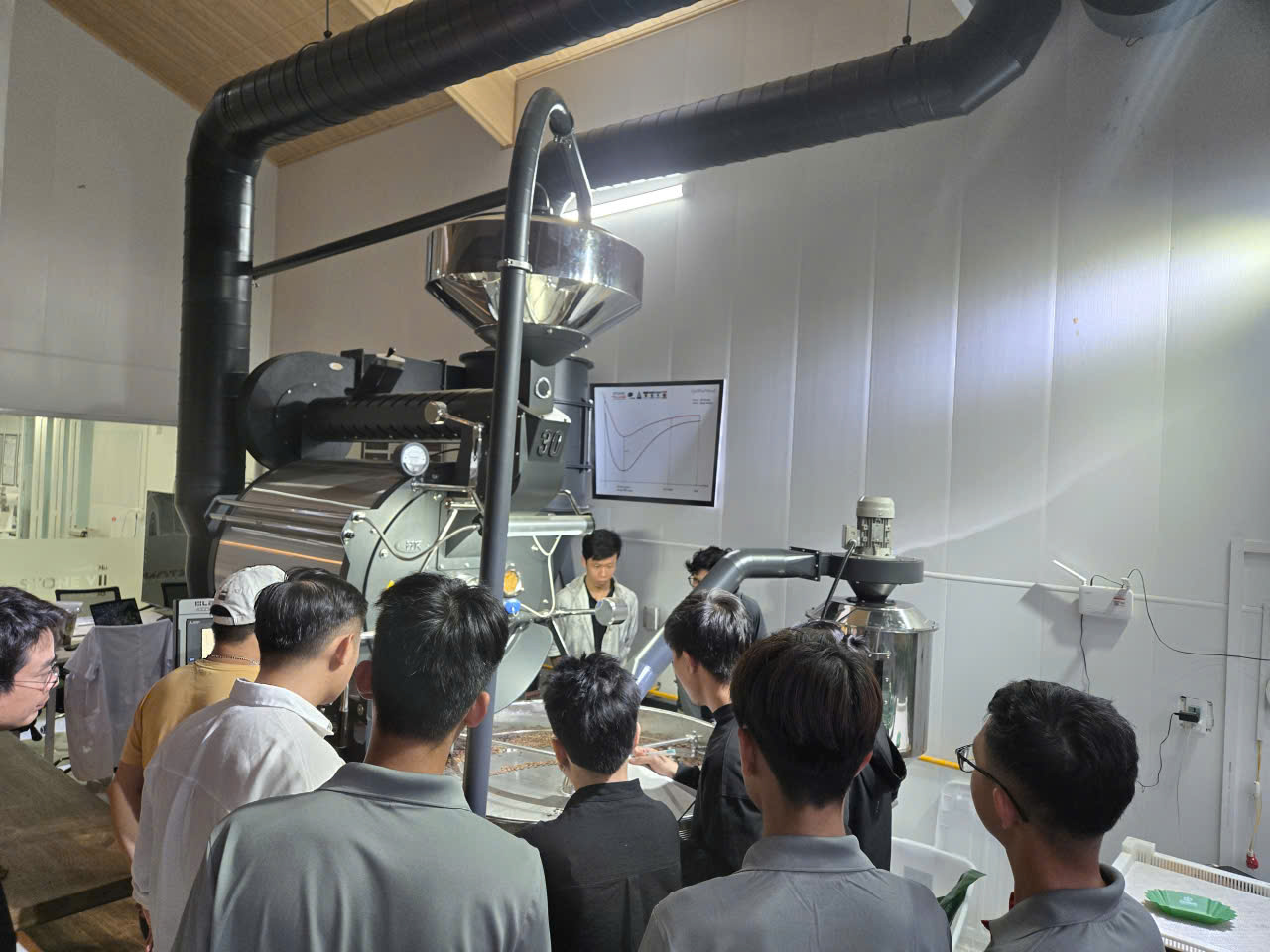 Buổi hướng dẫn vận hành máy rang LBN 30kg, học viên quan sát đường cong profile rang treo tường