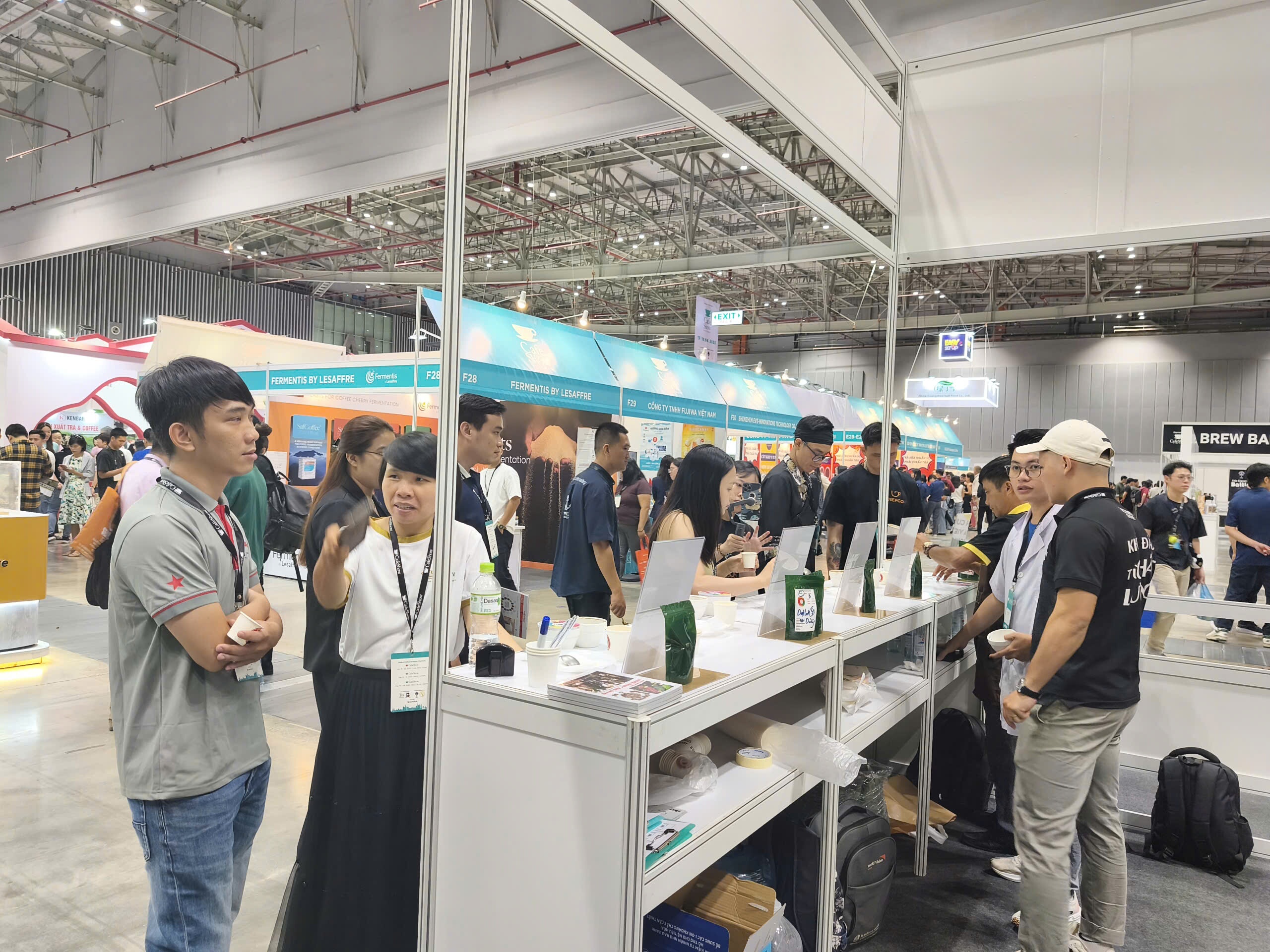 Bàn nếm cà phê tại gian hàng CafeShow Vietnam, khách tham quan đứng thử mẫu quanh quầy