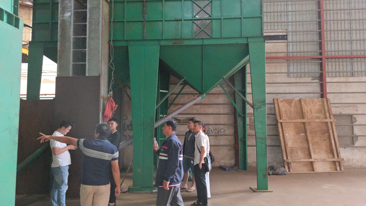 Nhóm người nghe giới thiệu quy trình ngay trong khu vực máy móc của nhà máy cà phê
