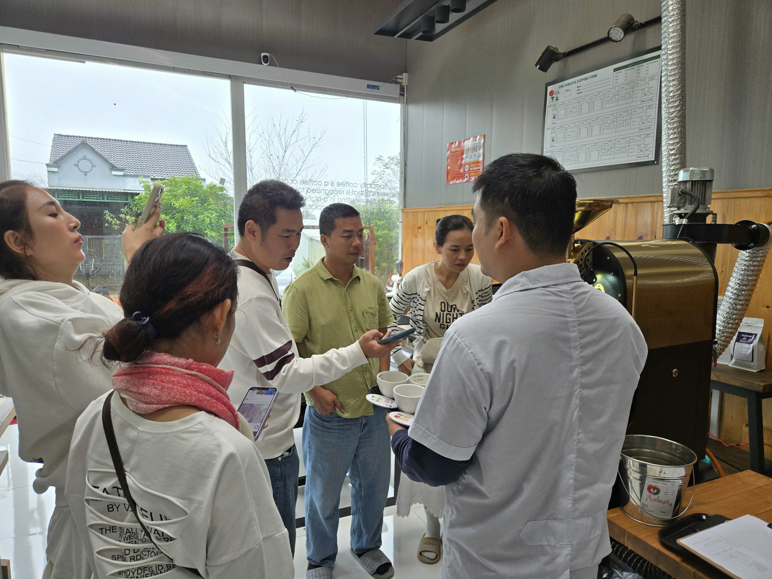 Khách theo dõi mẻ rang trong tour du lịch cà phê Măng Đen