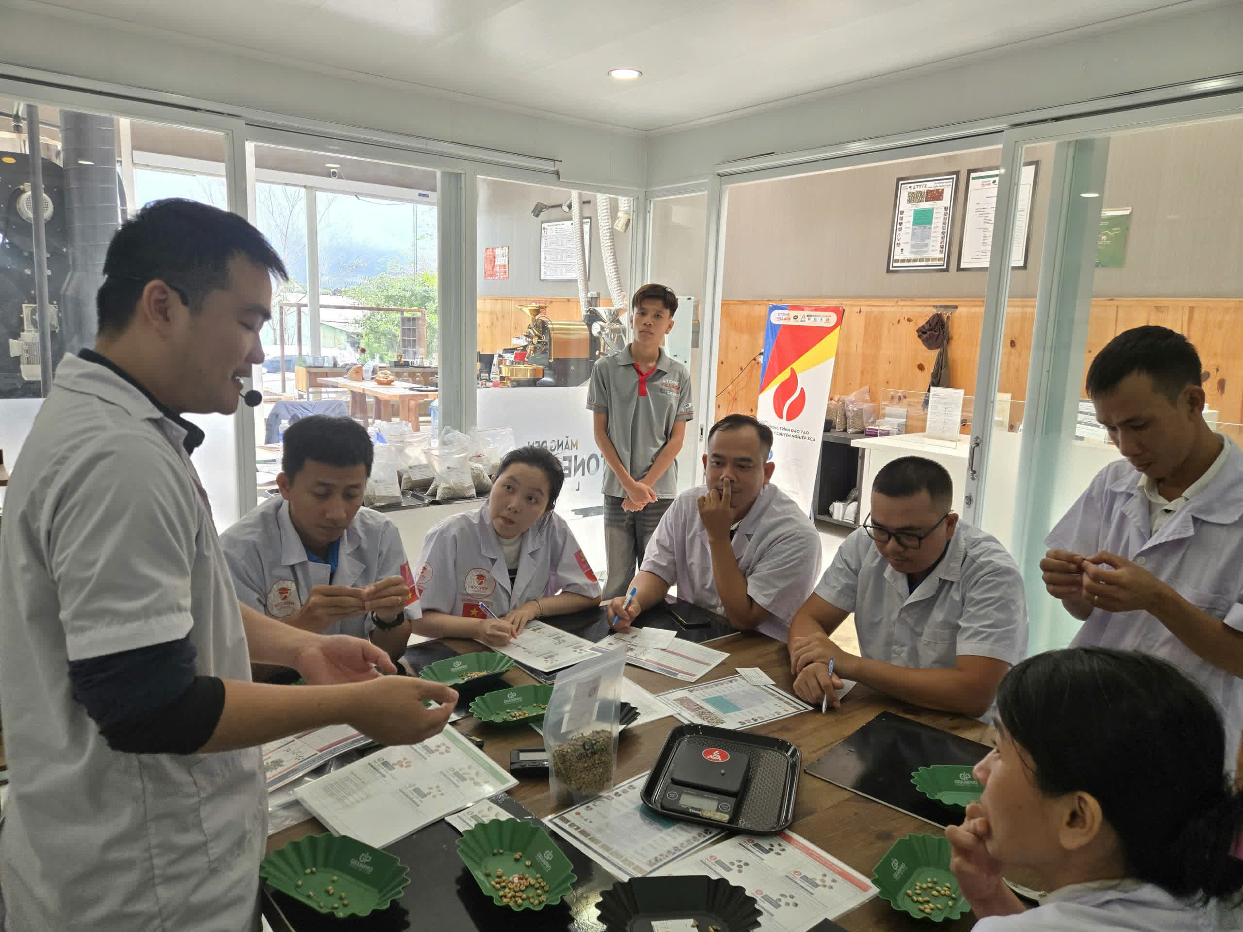 Giảng viên hướng dẫn mẫu nhân xanh trên khay tại lớp SCA Green Bean