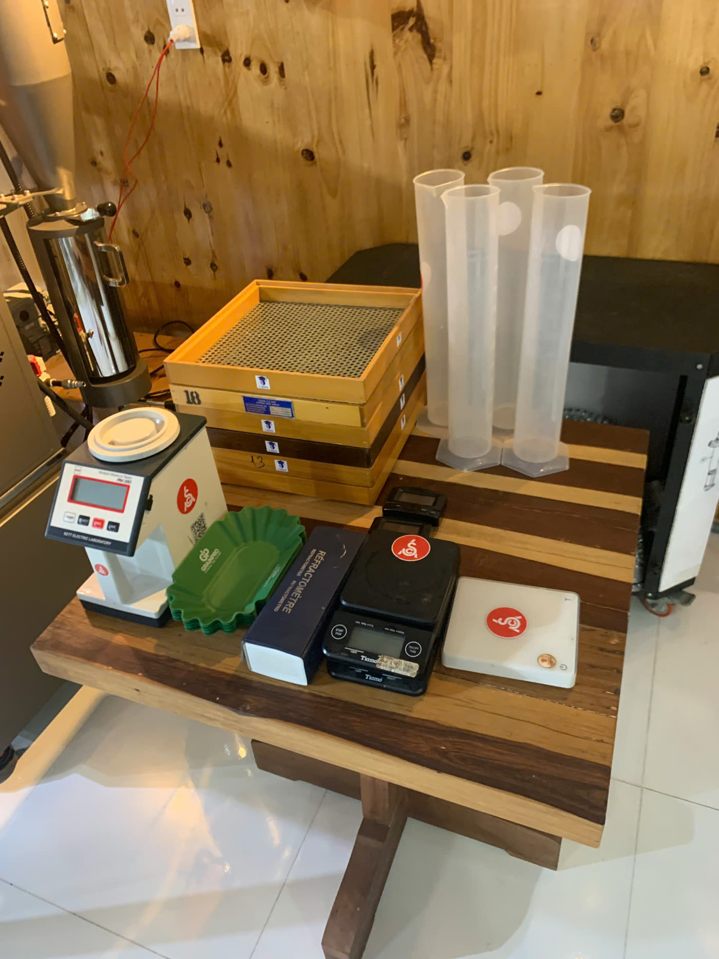 Máy đo độ ẩm Kett, bộ sàng cỡ hạt, ống đong và cân dùng trong bài Physical Assessment của lớp Q Grader