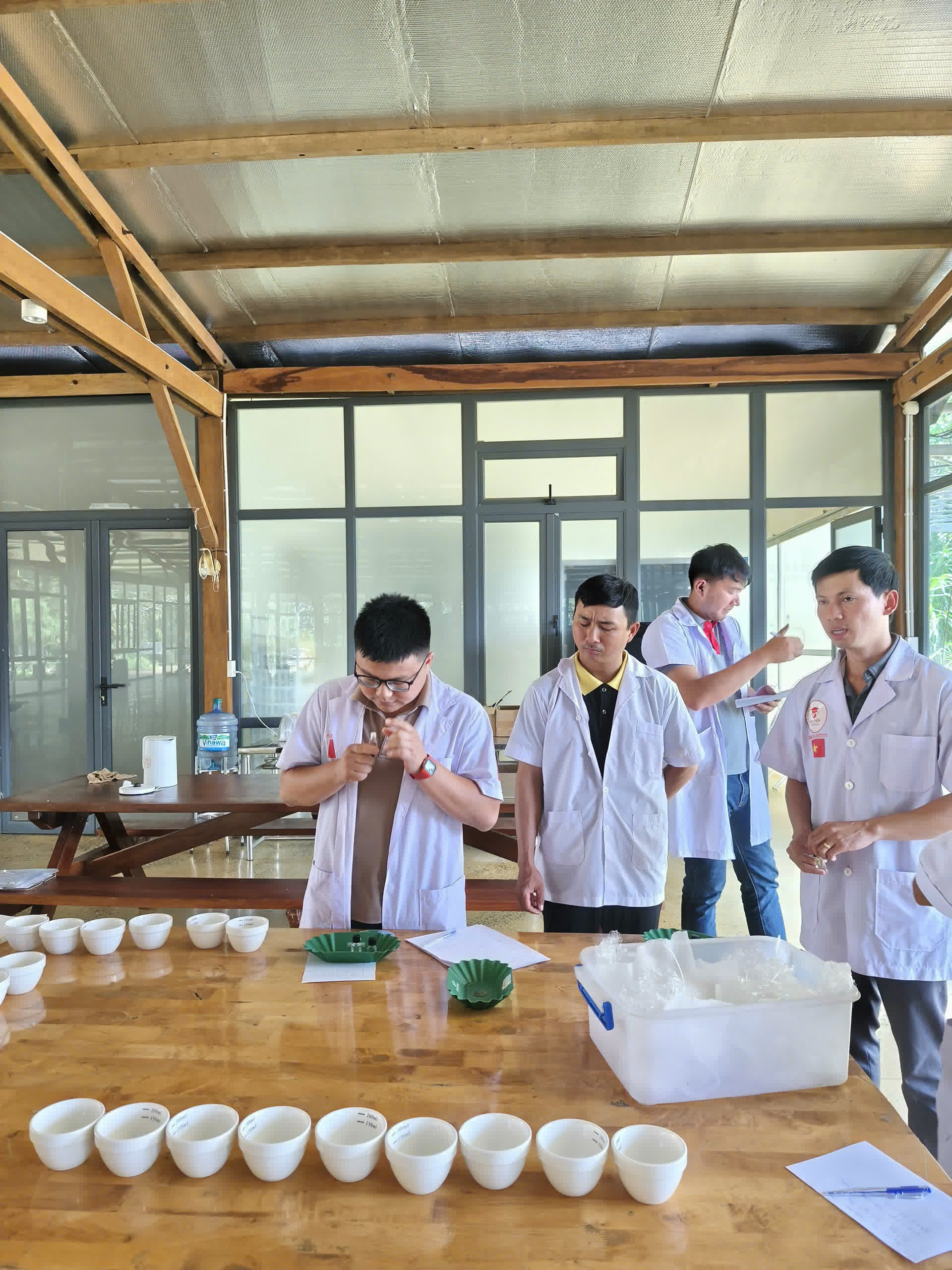 Bàn cupping đặt trong nhà kính khung gỗ tại Làng Hama, Đắk Nông