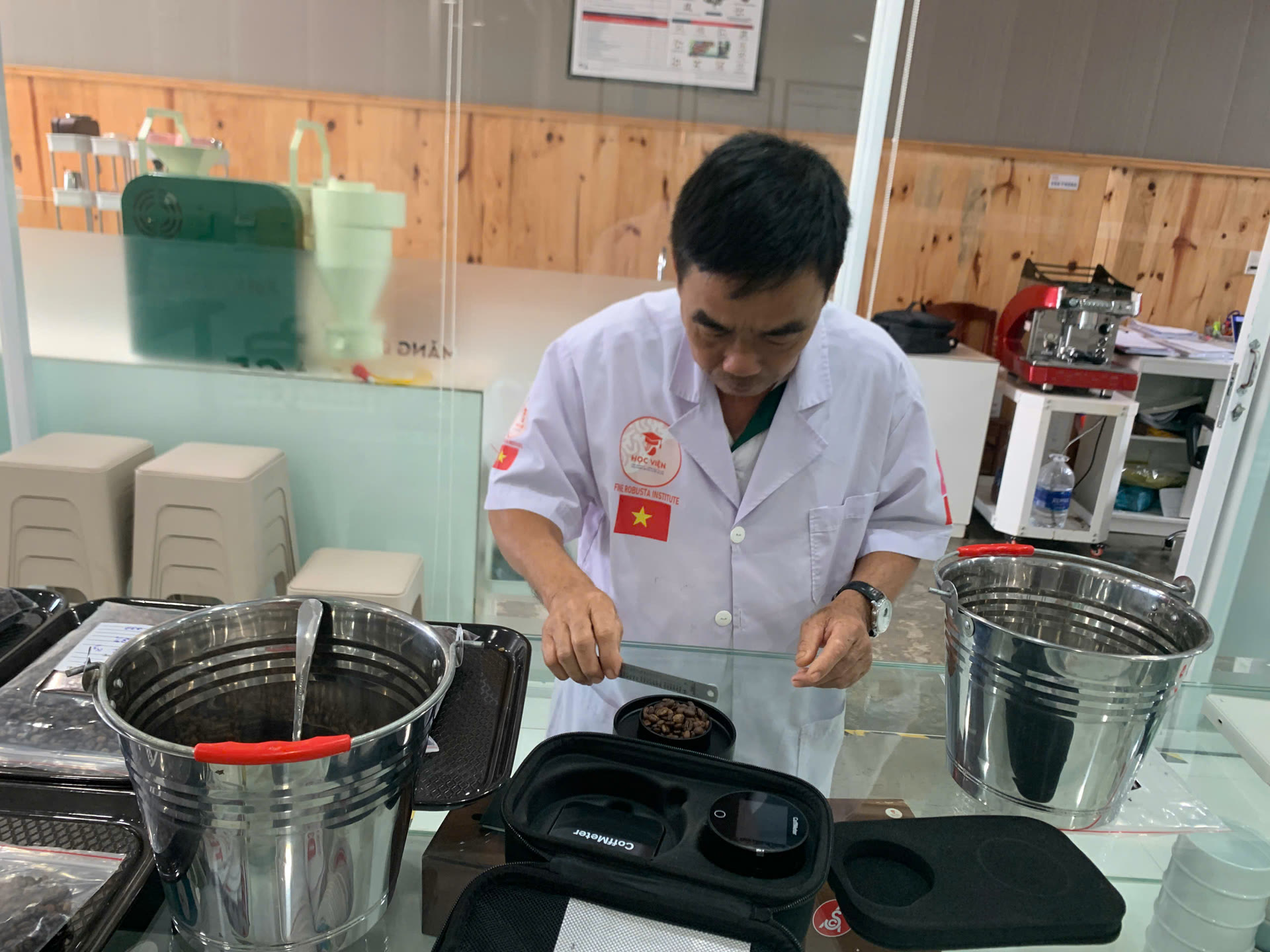 Học viên cho hạt rang vào cốc đo của máy đo màu rang CoffMeter