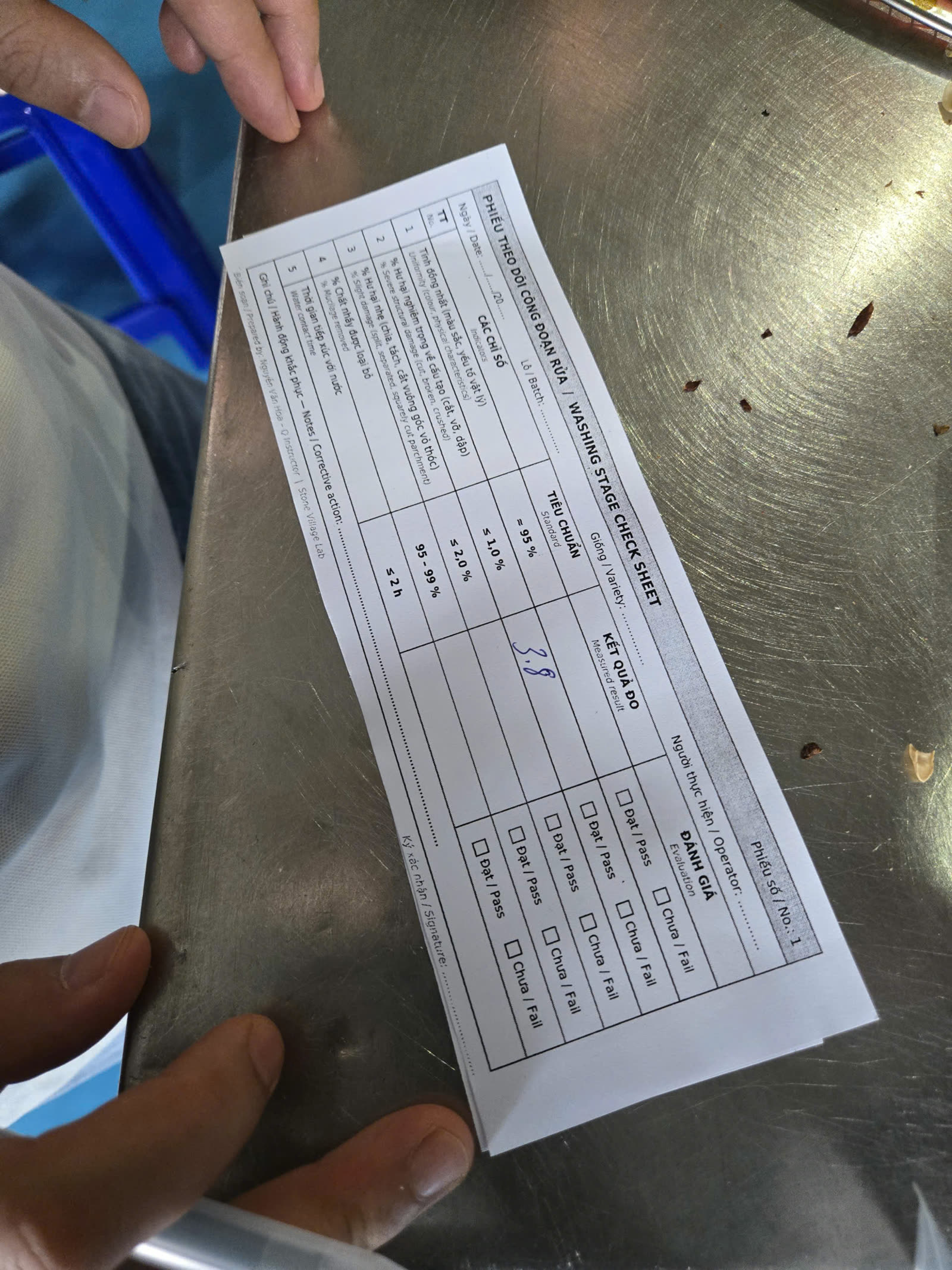 Phiếu ghi chép đặt trên bàn thép trong xưởng