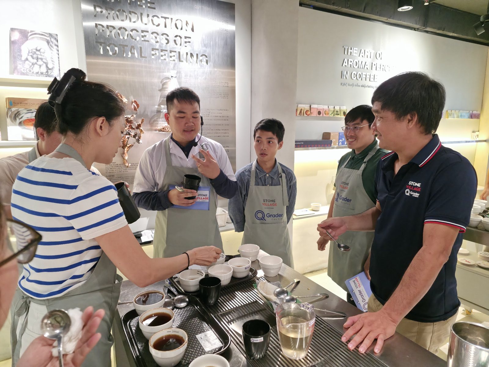Giảng viên trao đổi với nhóm học viên bên bàn cupping