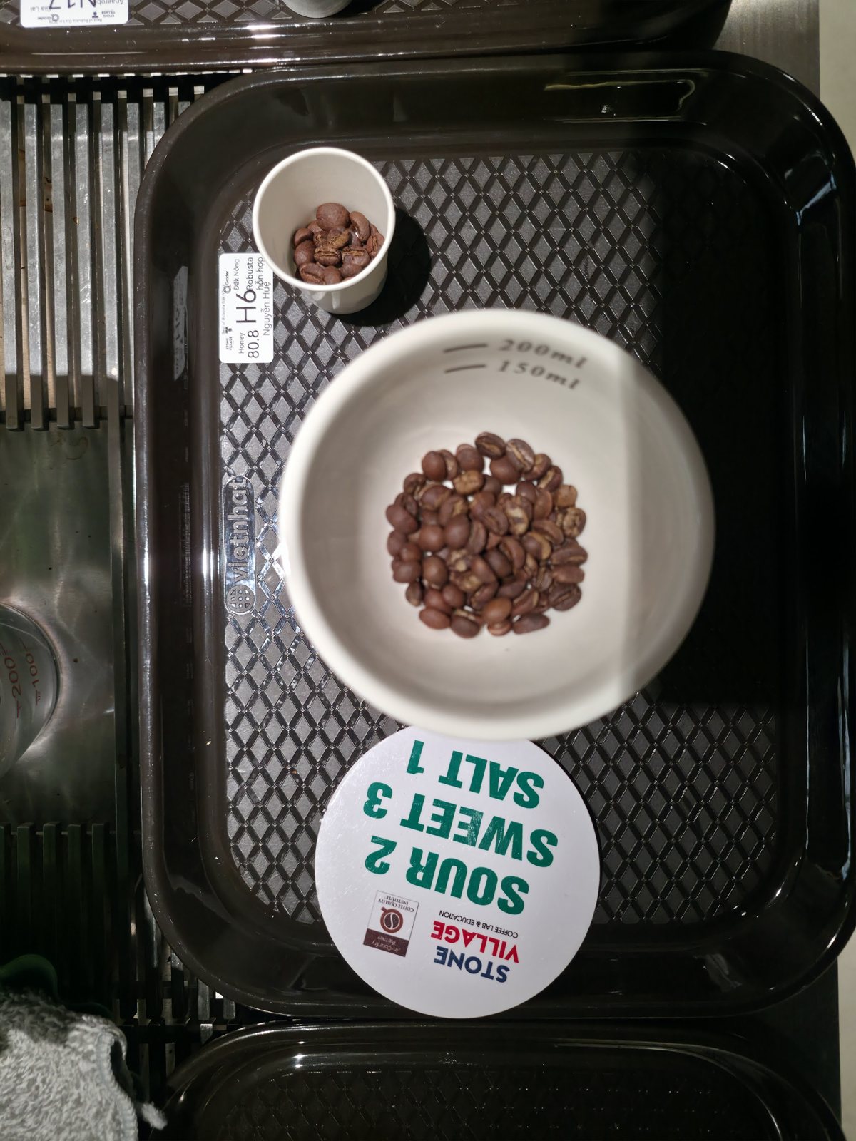 Hạt Robusta rang trong chén trắng trên khay đen