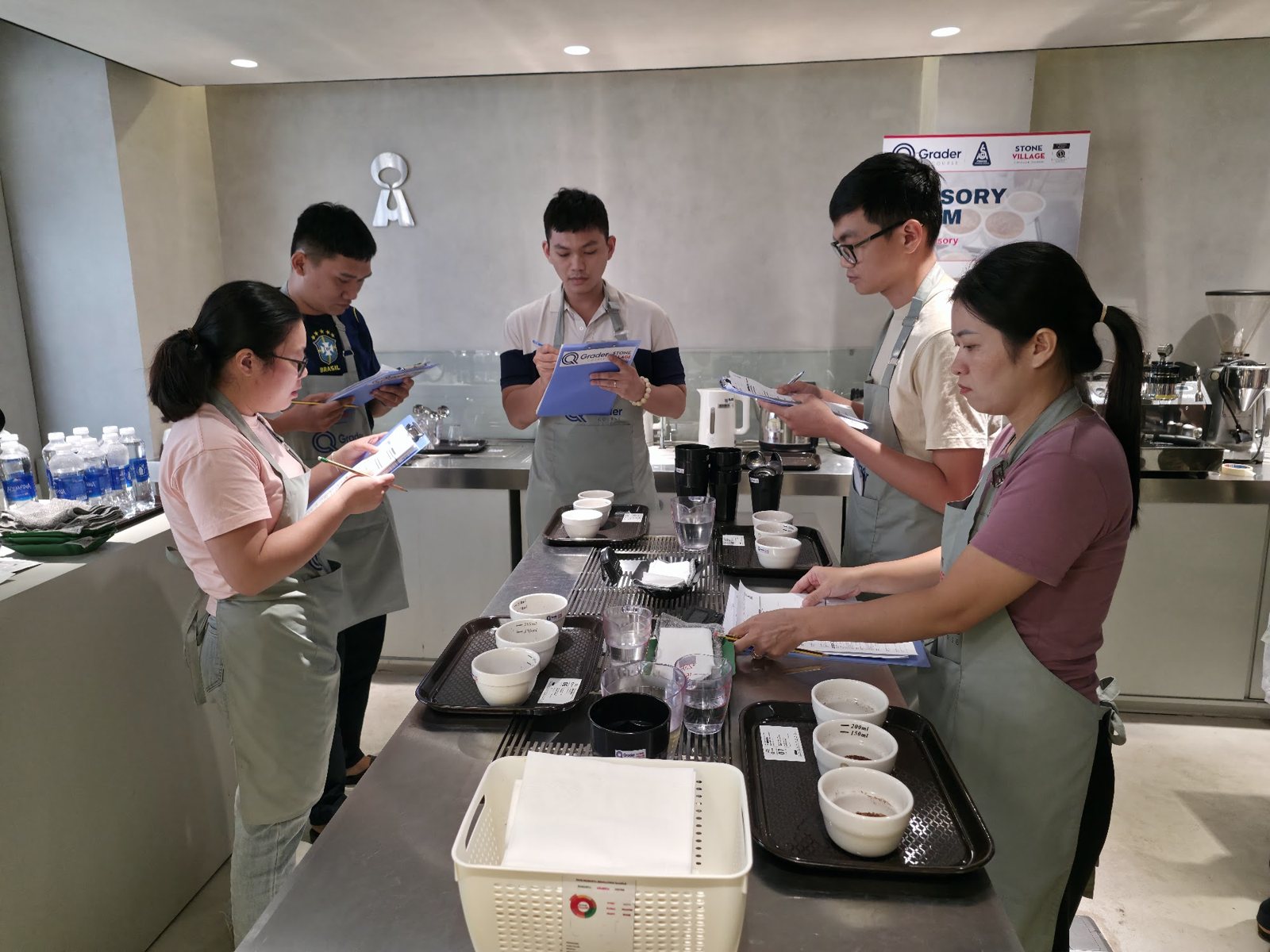 Học viên ghi biểu mẫu quanh bàn mẫu cà phê
