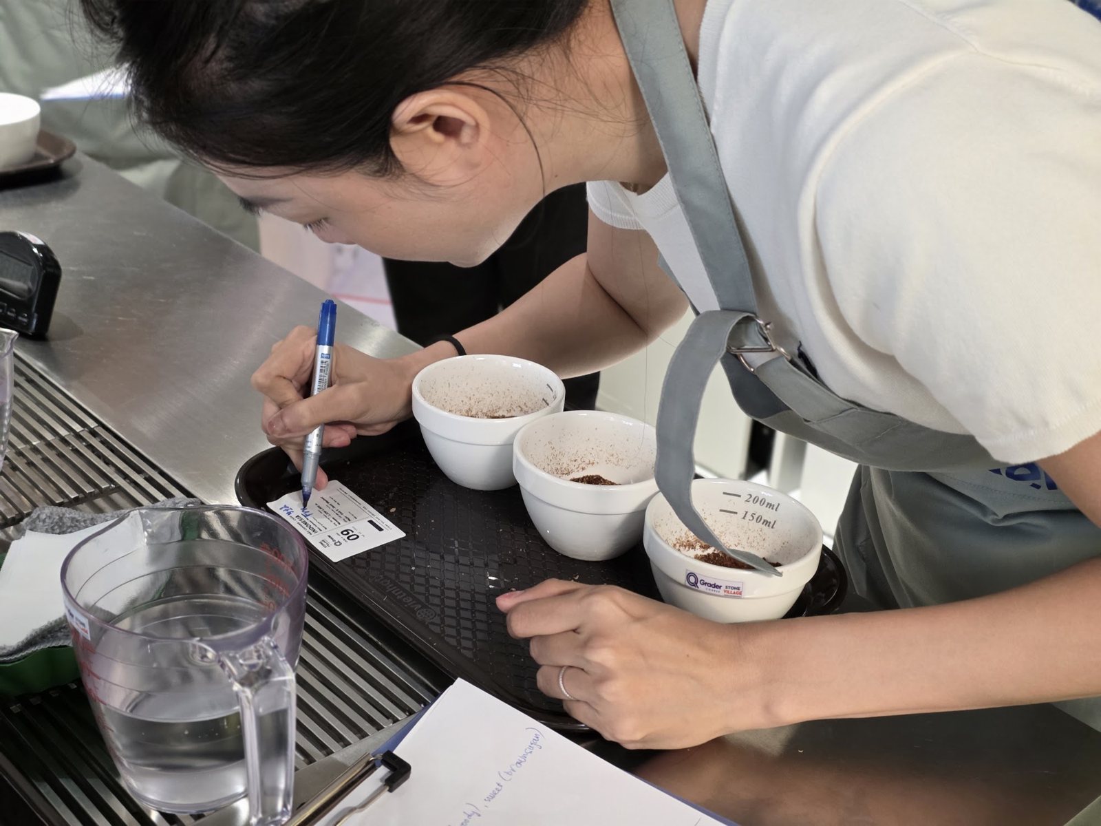 Học viên ghi chép bên khay ba chén cà phê