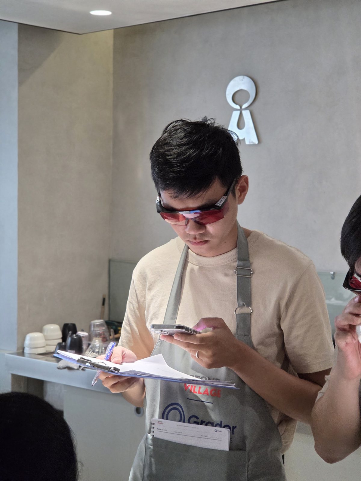 Học viên đeo kính đỏ ghi phiếu sau khi nếm