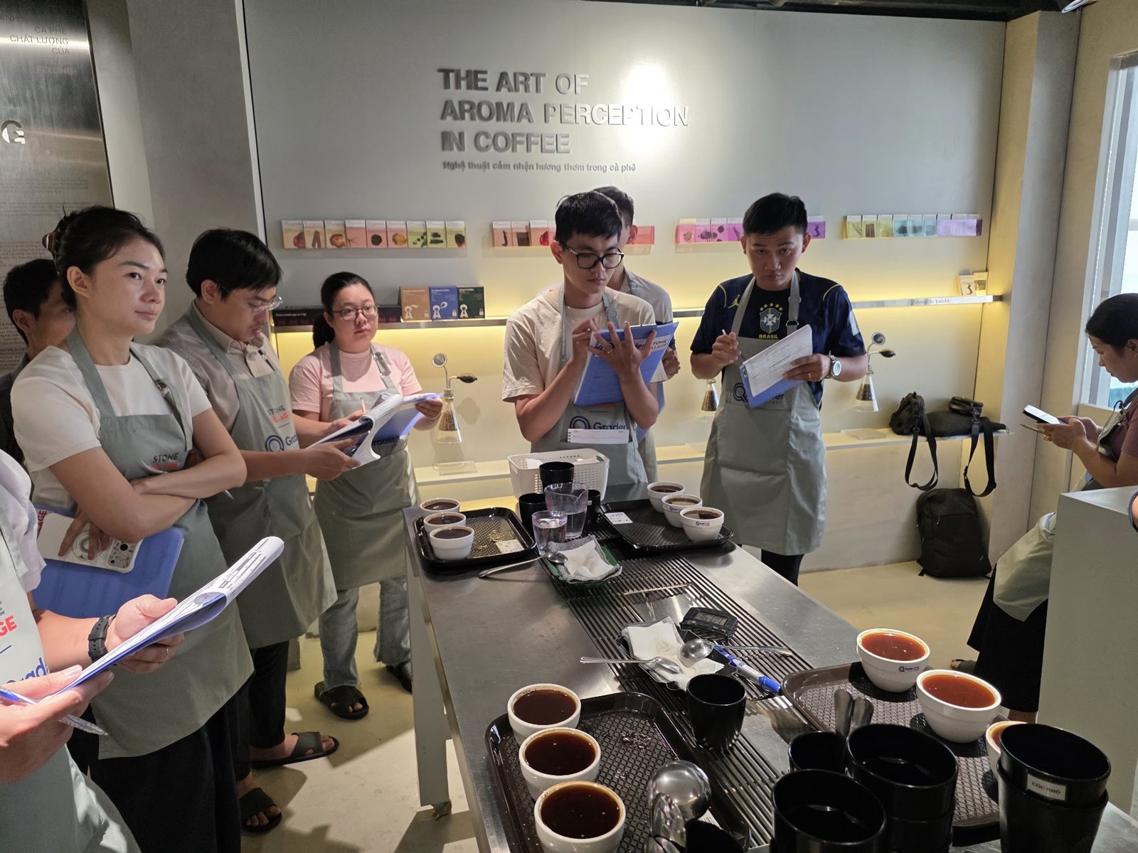 Cả nhóm học viên đứng quanh bàn cupping cầm biểu mẫu