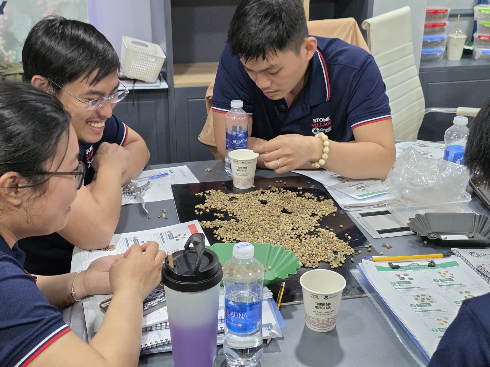 Nhóm học viên soi lỗi nhân xanh quanh tấm nền đen