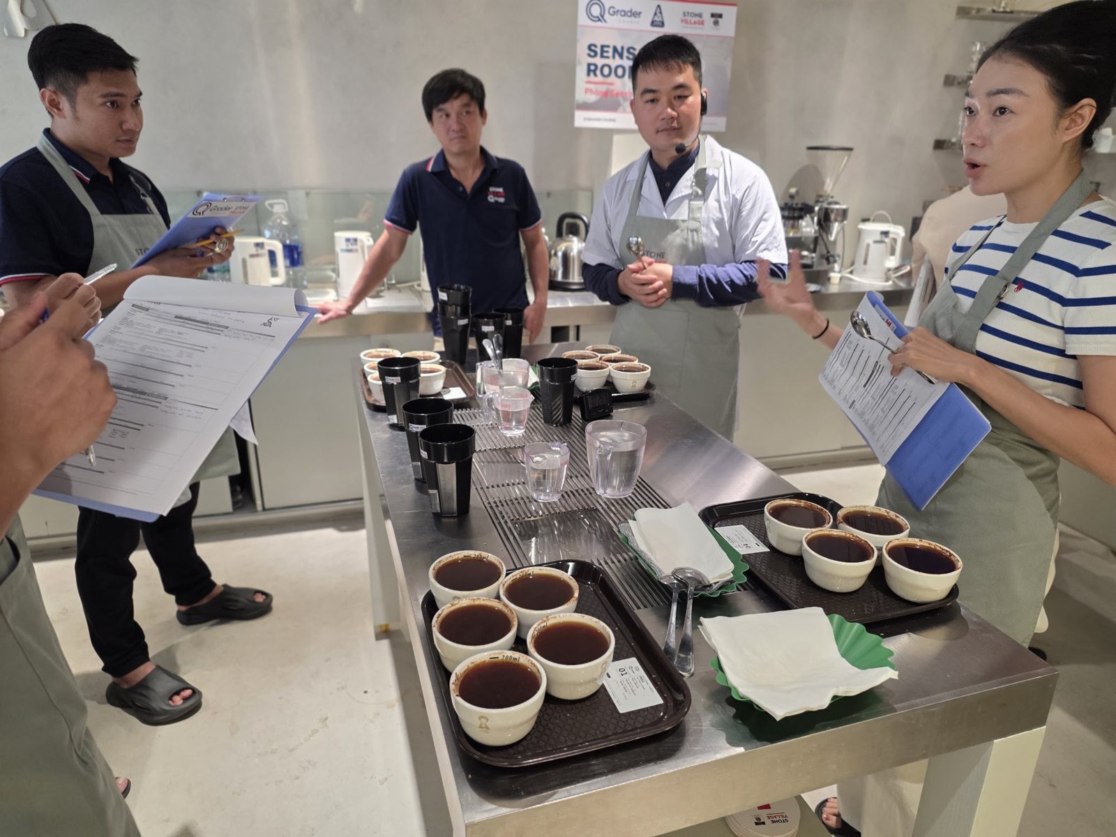 Học viên trao đổi kết quả cupping quanh bàn mẫu